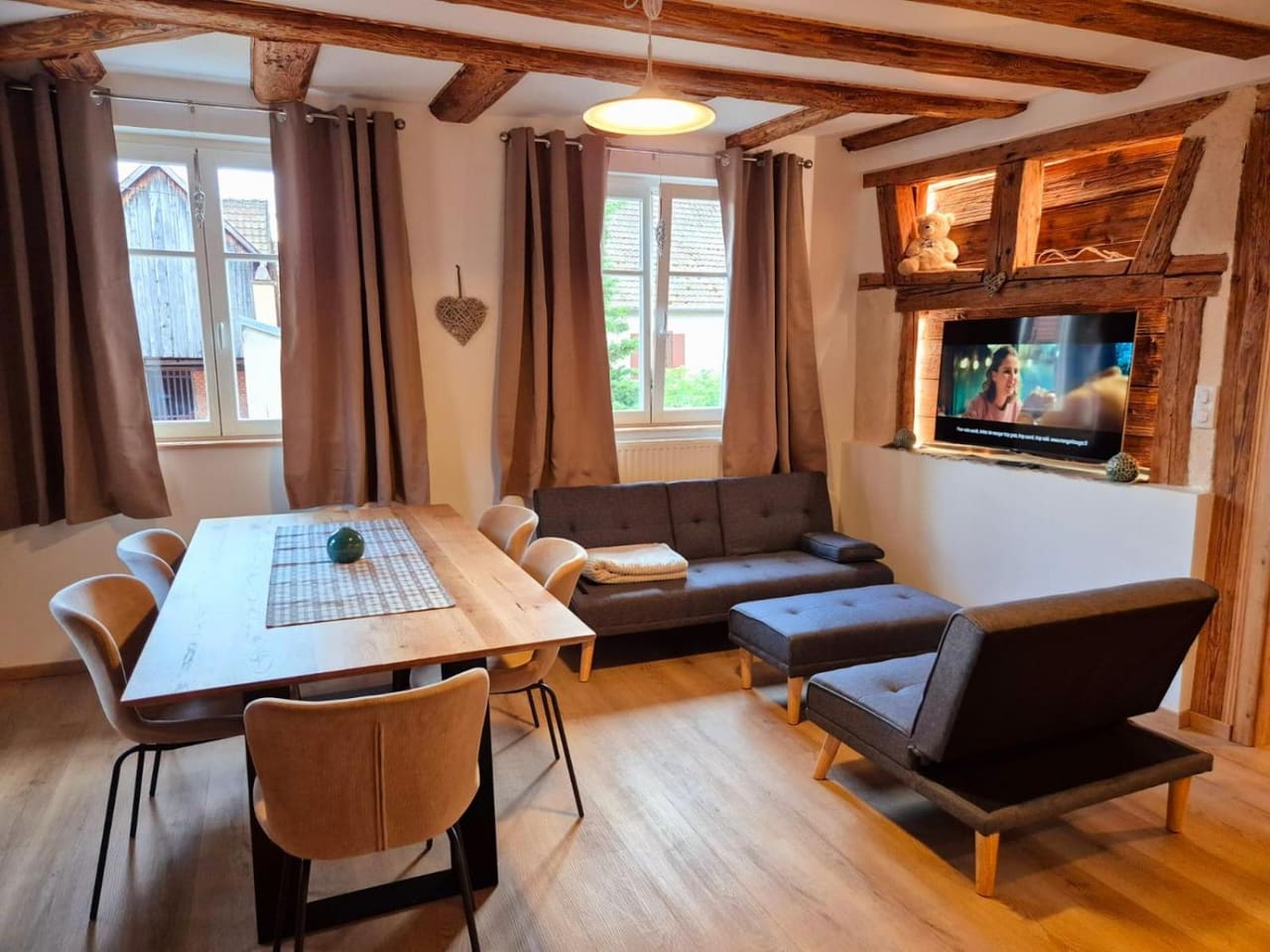Pièce de vie du gîte Au Cœur de l'Ours avec grande table en bois et canapé